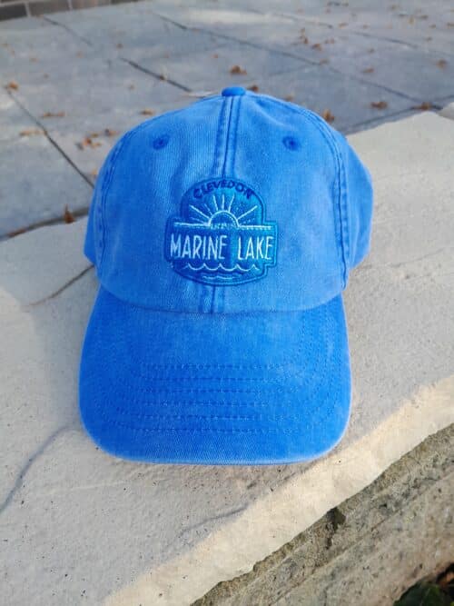 Blue cap with a curved peak and an embroidered Clevedon Marine Lake logo on the front.